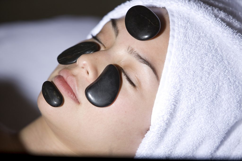 Woman with hot rocks facial treatment